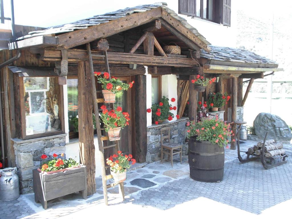 a wooden structure with potted plants and flowers at Maison Lazier in Châtillon