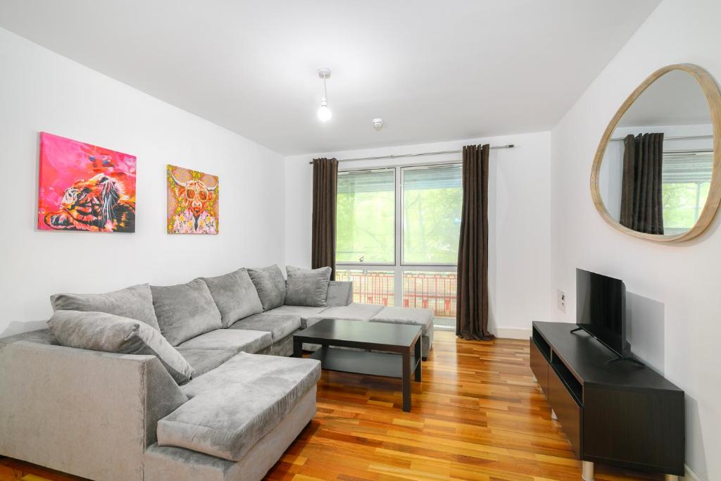 a living room with a gray couch and a table at Modern 1BR Apartment near Edgbaston Cricket Ground in Birmingham
