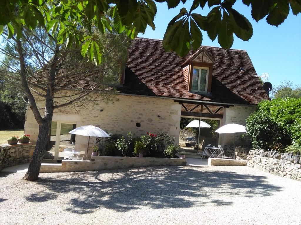 een huis met 2 parasols en een patio bij Bergerie de Lagarrigue in Baladou