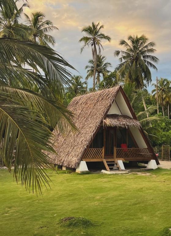 a resort with a thatched roof and palm trees at Bungalow in Katiet