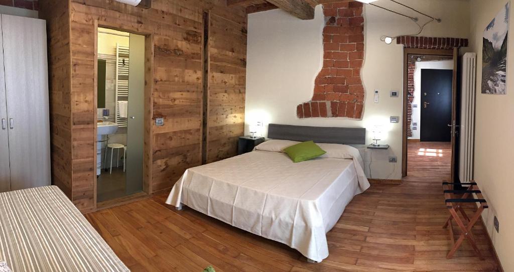 a bedroom with a bed and a brick wall at Osteria Senza Fretta Rooms for Rent in Cuneo