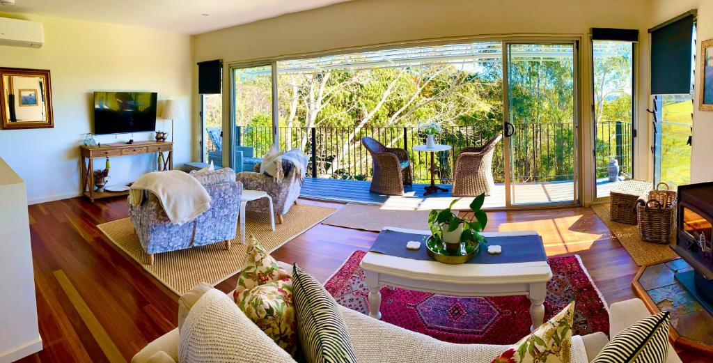 a living room filled with furniture and a large window at "La Petite Grange" Maleny in Maleny