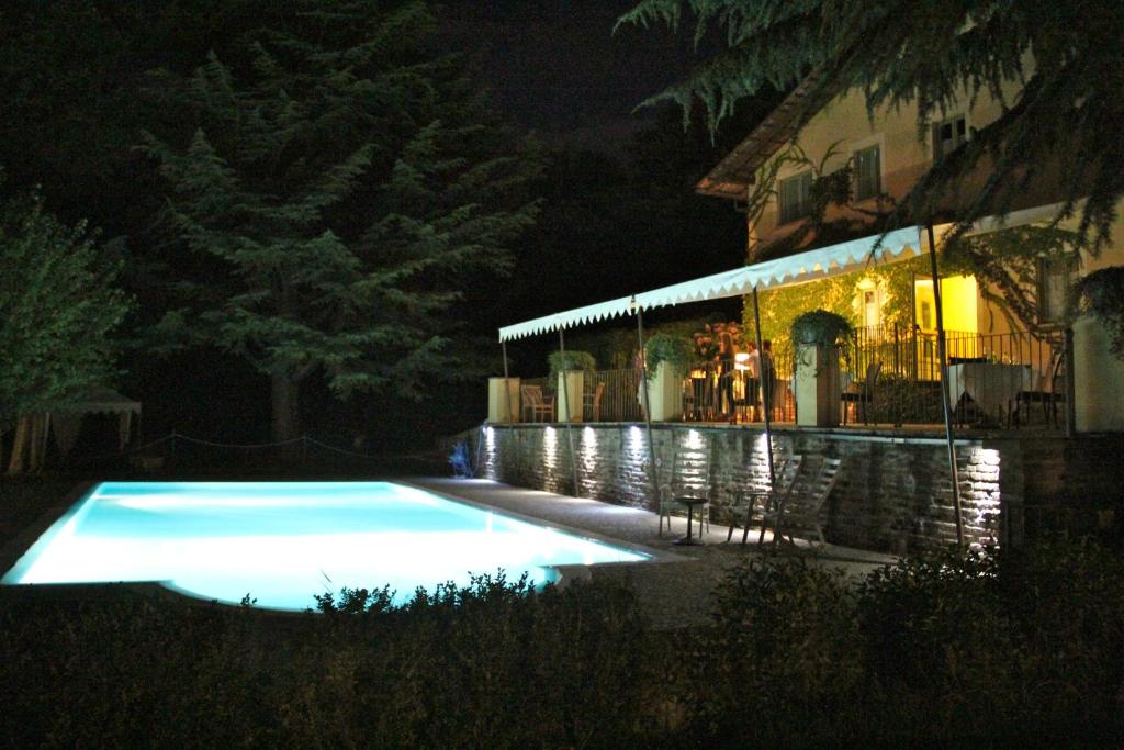 a swimming pool in front of a building at night at Locanda Maison Verte in Cantalupa