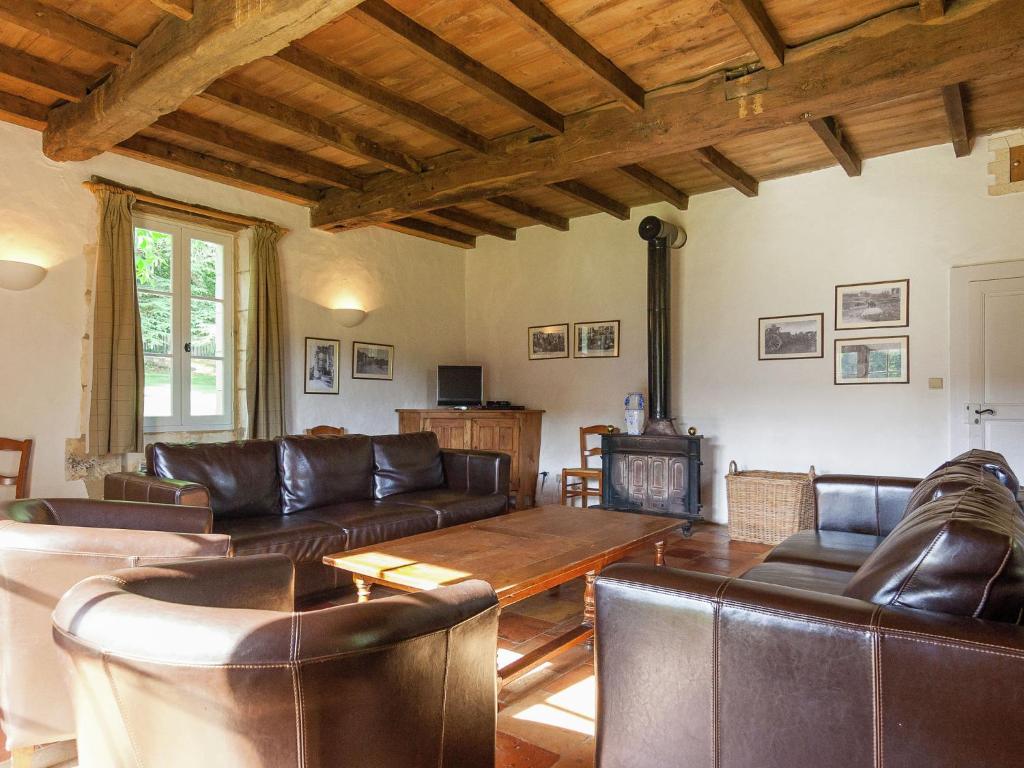a living room with leather furniture and a fireplace at Impressive restored farmhouse with private pool surrounded by woods in Campsegret
