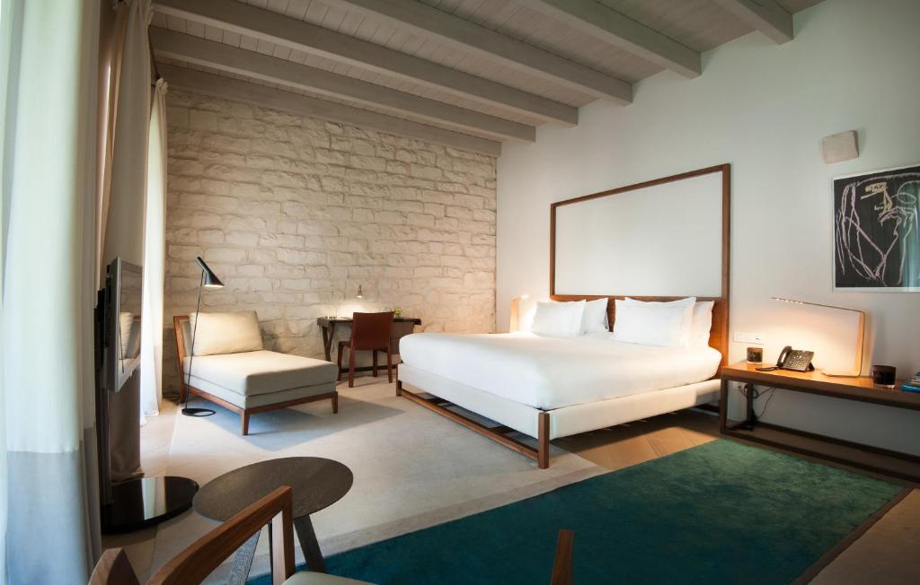 a bedroom with a white bed and a chair at Mercer Hotel Barcelona in Barcelona