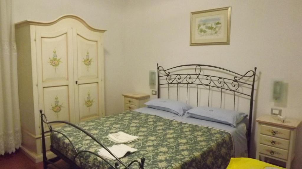 een slaapkamer met een bed met een groene en witte sprei bij Casa Marina in Fosdinovo