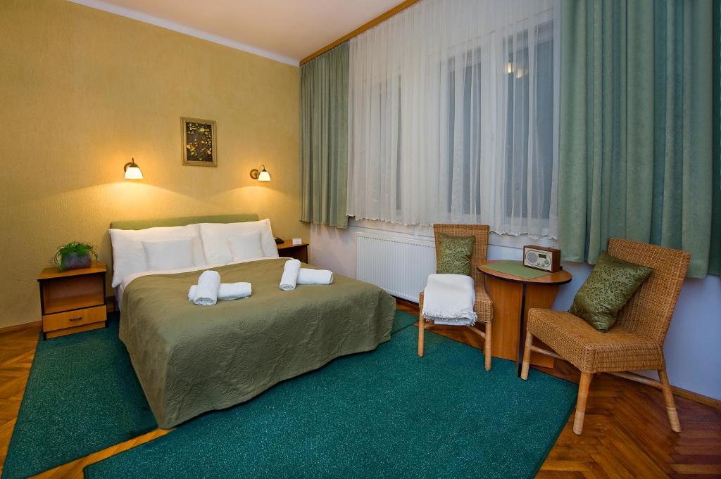 a hotel room with a bed and chairs and a window at Dom Wypoczynkowy Helunia in Jurata