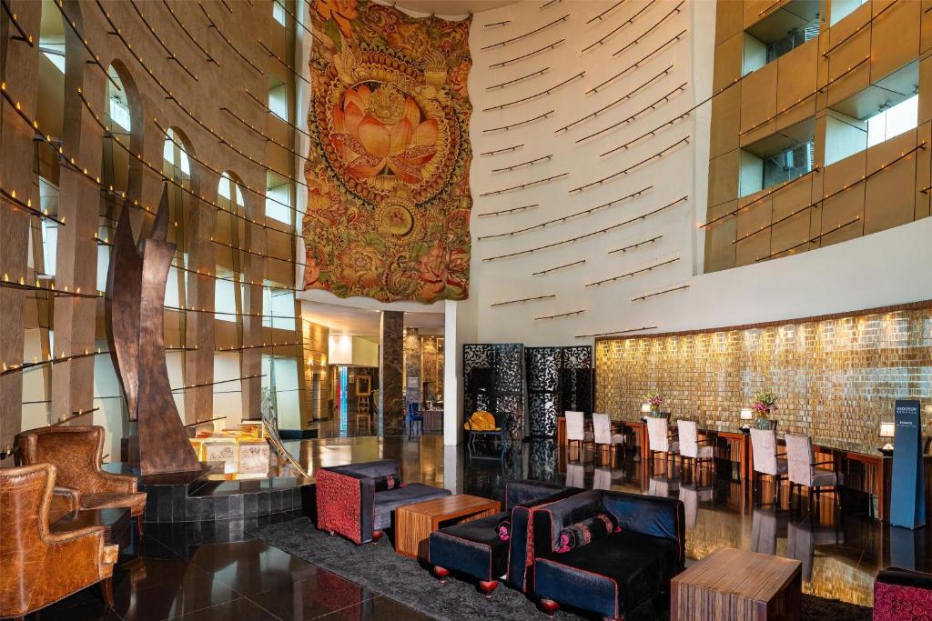 a lobby with chairs and a large rug on the wall at Radisson Blu Hotel, Ludhiana in Ludhiana