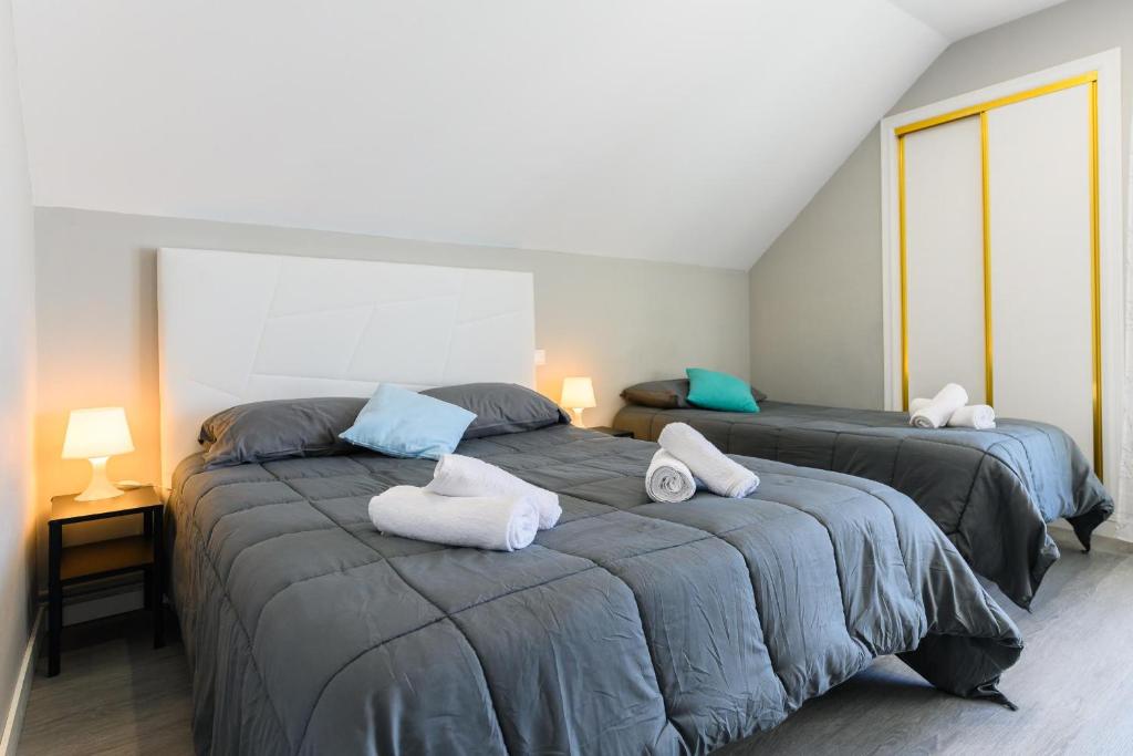 two beds with towels on them in a bedroom at VILLA Formonte in Los Ángeles de San Rafael
