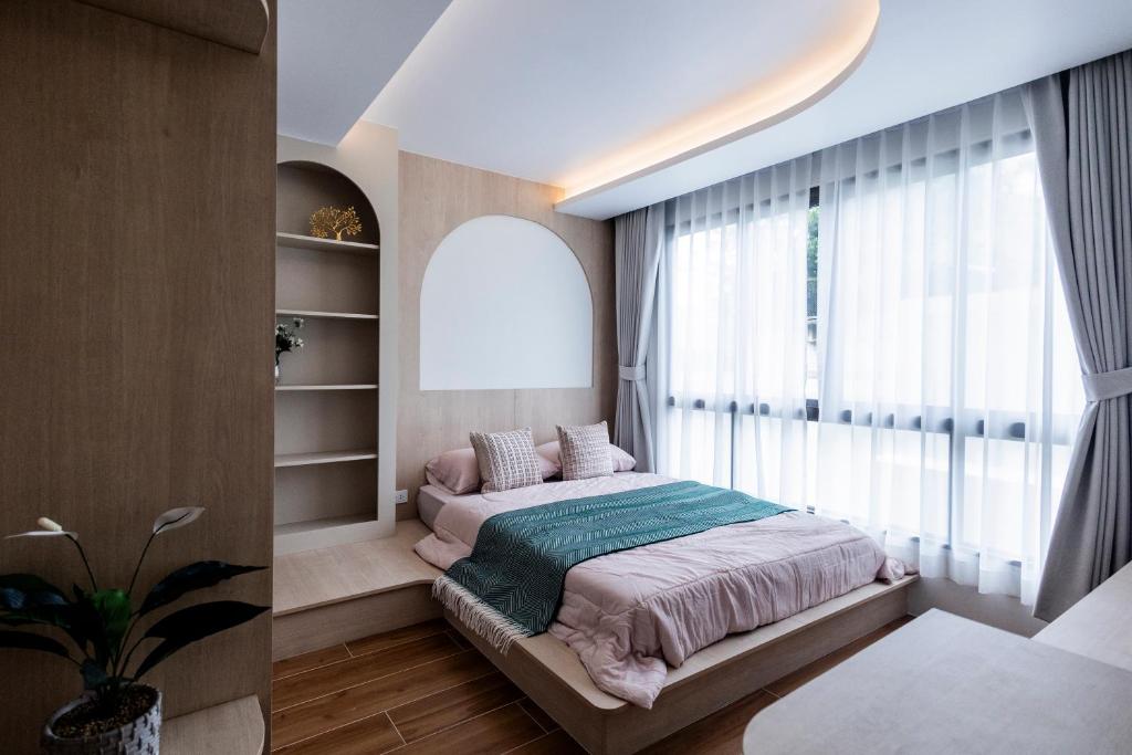 a bedroom with a bed and a large window at FantaSea condo Kamala 204 in Kamala Beach