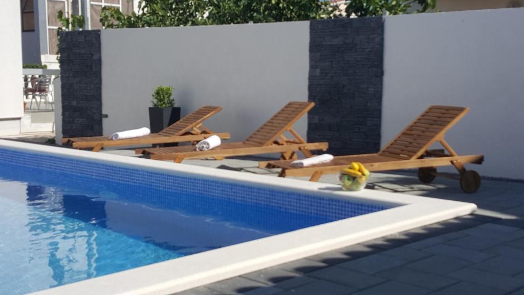 two lounge chairs sitting next to a swimming pool at Apartment Laura in Vodice