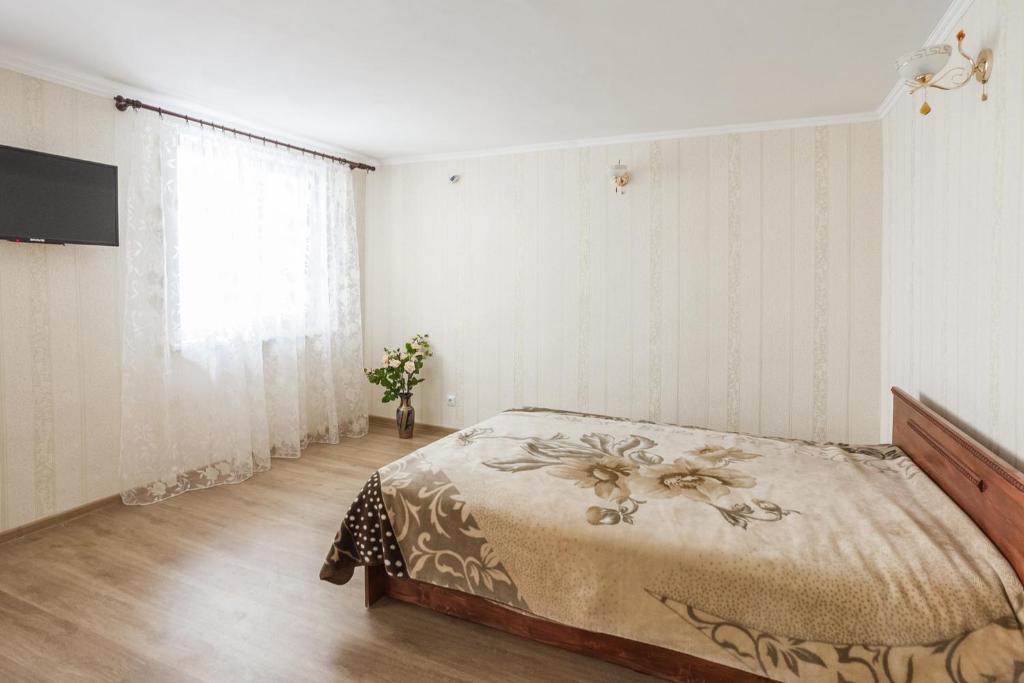 a bedroom with a bed and a television on a wall at Apartment on Zhukovskogo in Odesa