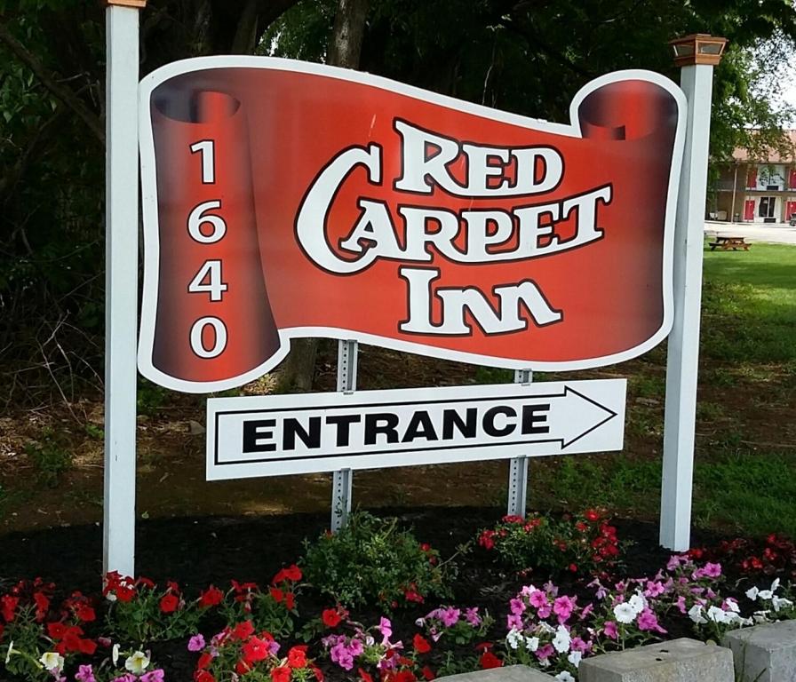 een bord voor een rood object bij de ingang bij Red Carpet Inn - Louisville in Louisville