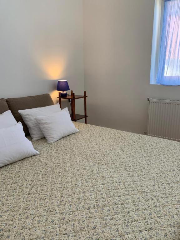 a bedroom with a bed with two pillows and a couch at Kempelen kúria in Esztergom