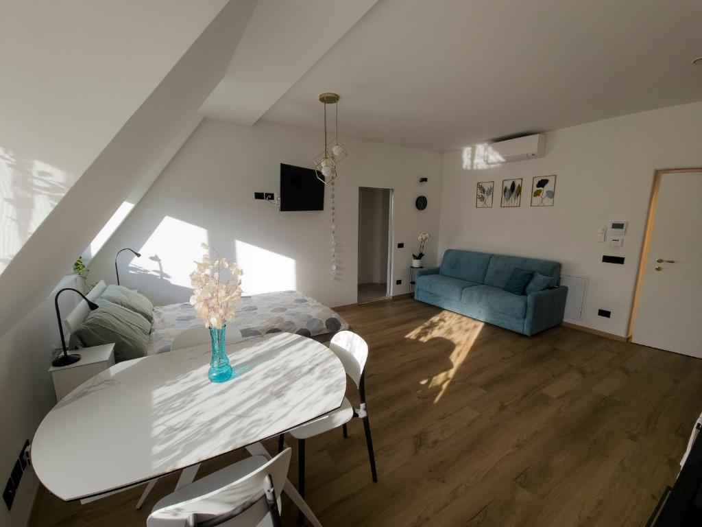 Una sala de estar con una mesa y un sofá azul. en Talvera Dream, en Bolzano