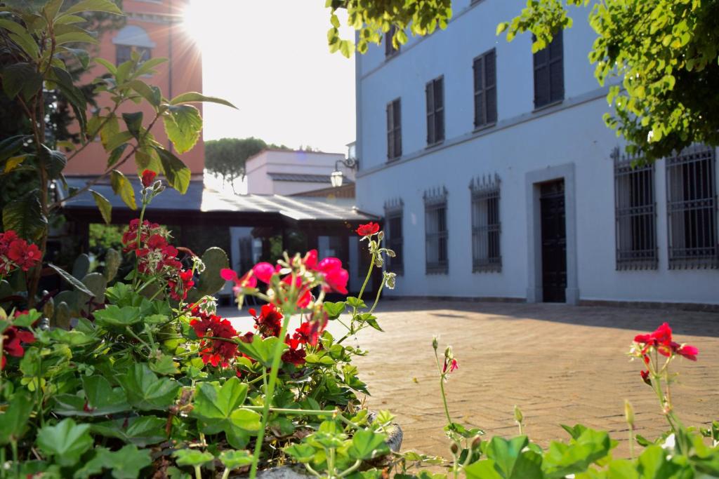 un groupe de fleurs rouges devant un bâtiment dans l'établissement Hotel La Torre, à Moie