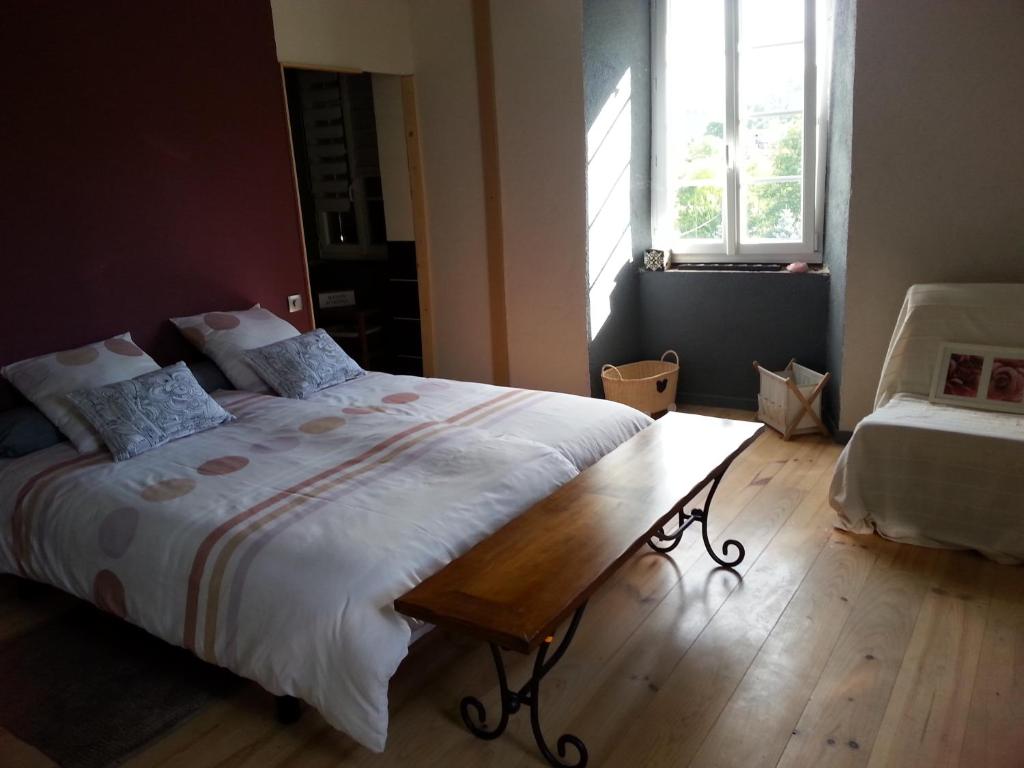 a bedroom with a large bed and a wooden floor at La Maison Des Badons in Saint-Basile