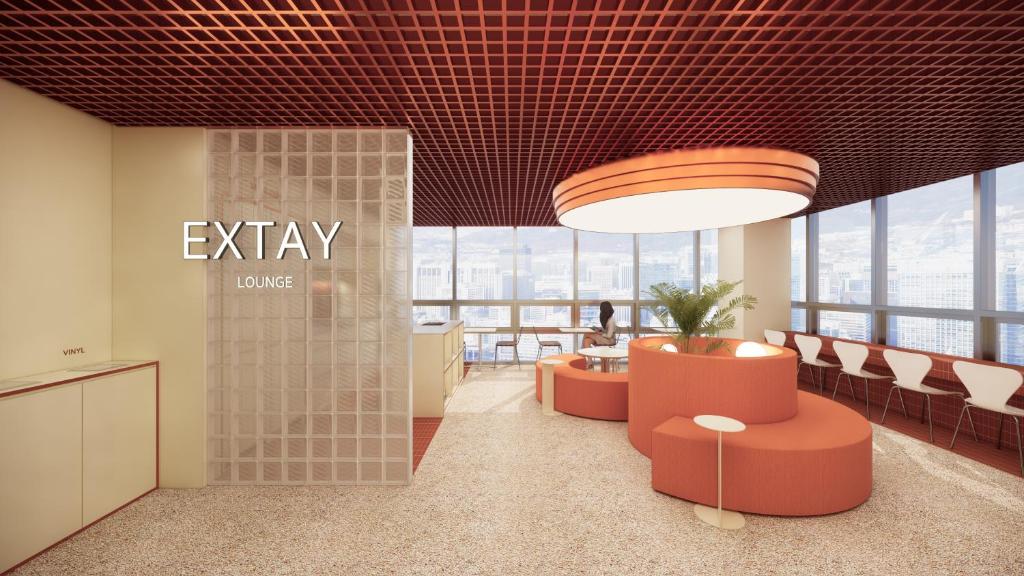 ソウルにあるTHE EXTAY Lounge Jongnoの大きな窓のあるオフィスロビー(オレンジの椅子付)
