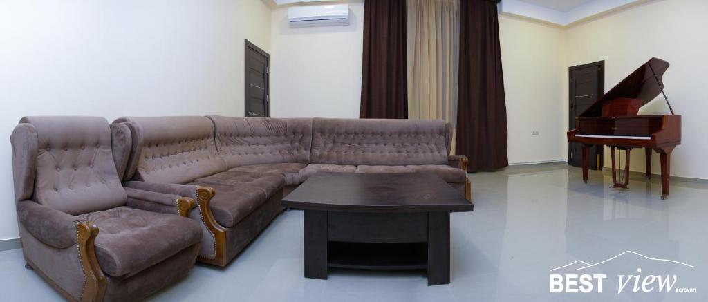 ein Wohnzimmer mit einem Sofa, einem Tisch und einem Klavier in der Unterkunft Best View Hotel in Yerevan