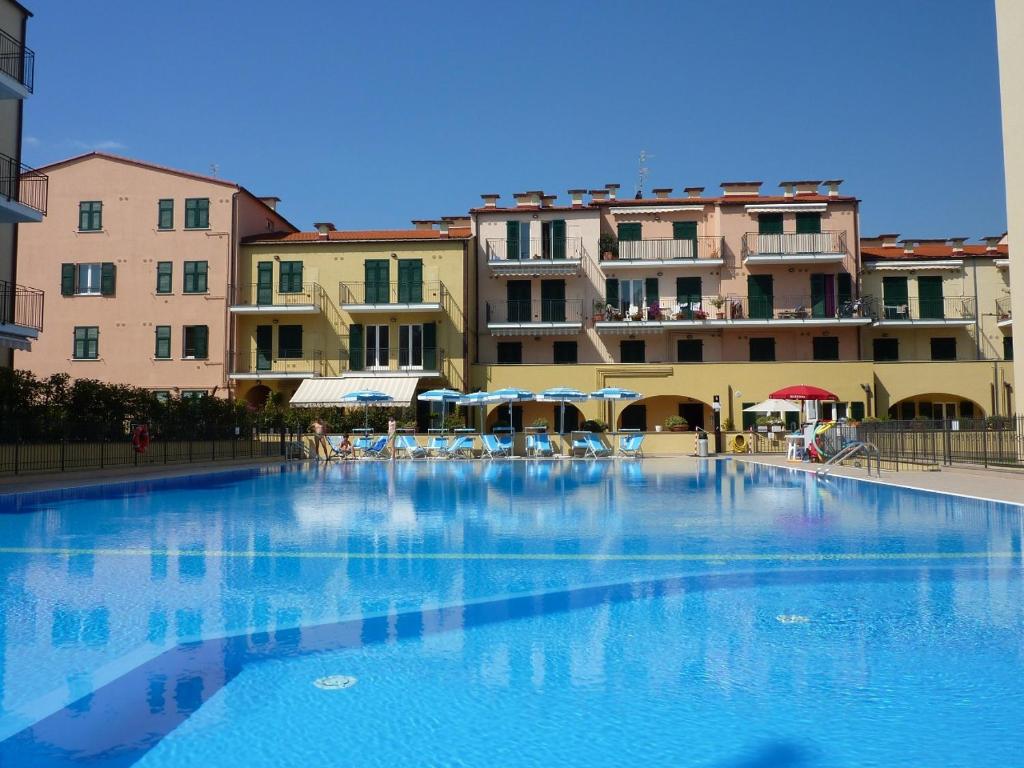 une grande piscine en face de certains bâtiments dans l'établissement Appartamento Vista mare con Piscina Cala di Sole, à Imperia