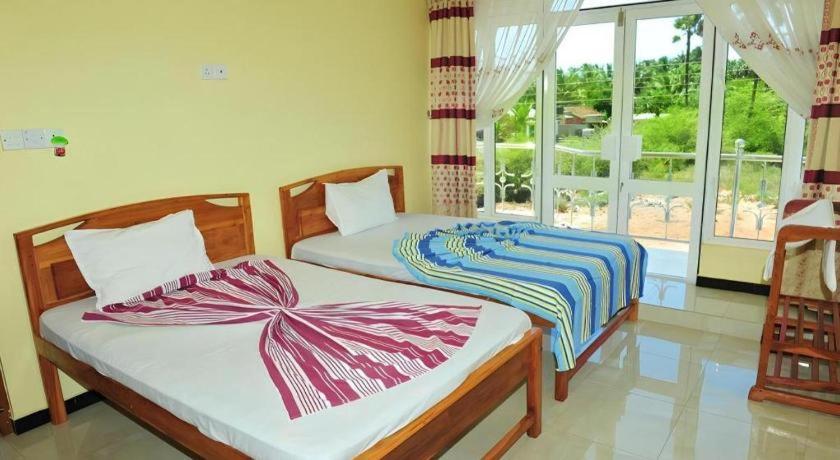 two beds sitting in a room with a window at Hotel Glee in Challi