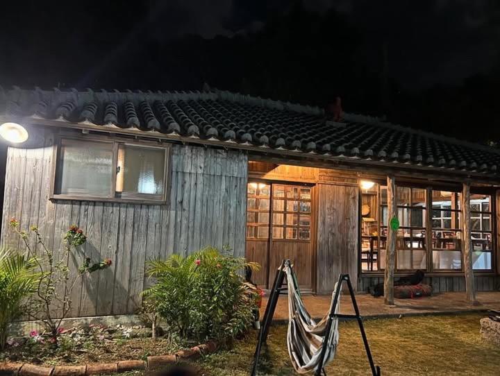 a house with a hammock in front of it at night at 島時間 Yagaji Village in Wada
