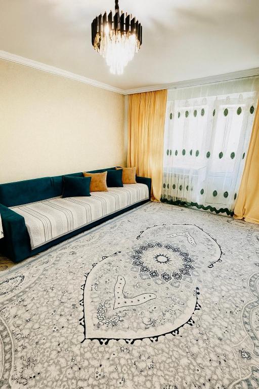 a living room with a couch and a rug at Биржан Сал центр 2 к in Taldykorgan