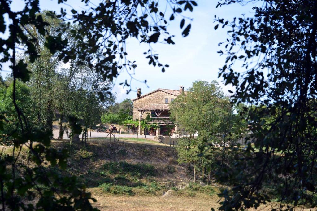 una casa in mezzo a un campo con alberi di Mas Sabaters - L'Era de Sabaters a Tavernoles