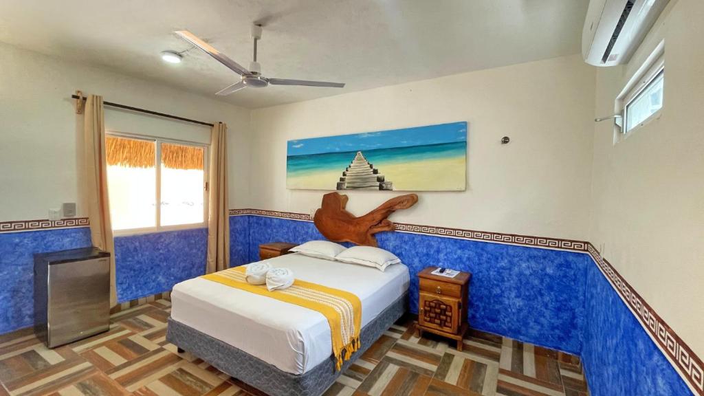 a bedroom with a bed and a tv in it at Maya Dreams Bacalar in Bacalar