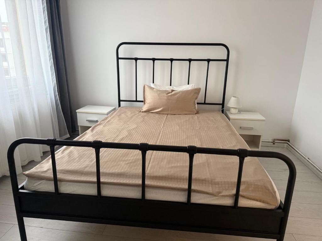 a bed with a black frame in a bedroom at REVO LUX Apartament in Baia Mare