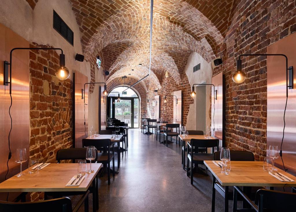 a restaurant with brick walls and tables and chairs at Entre Hotel by Zdrojowa in Wrocław
