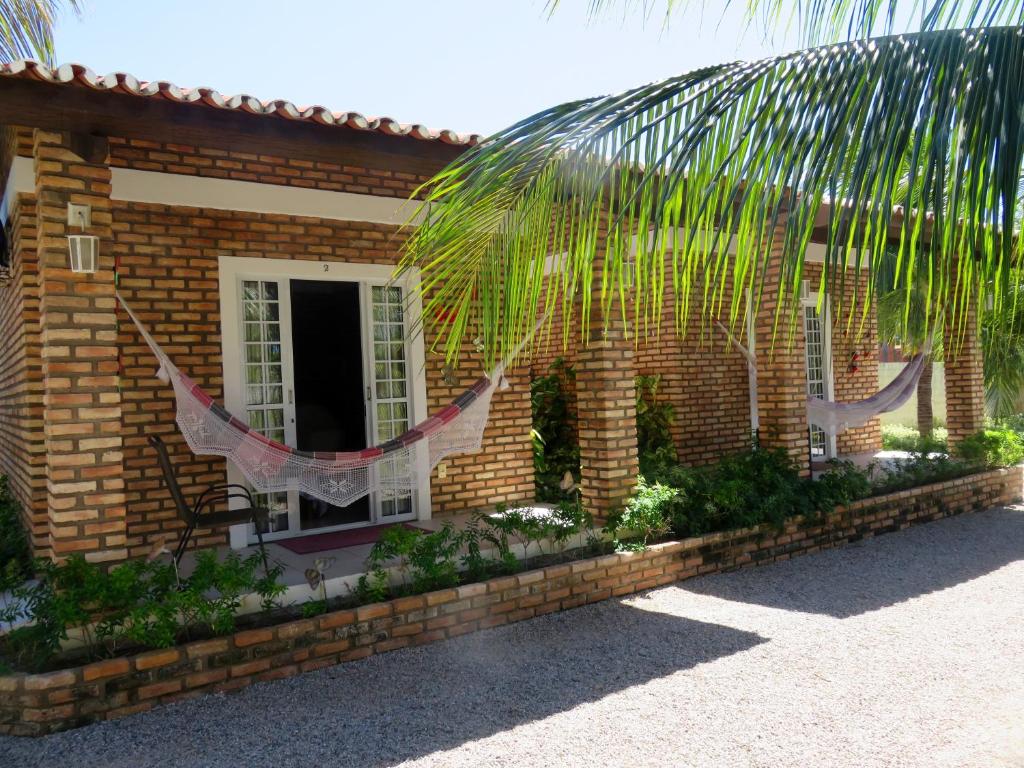 a house with a palm tree in front of it at Chacara do Alemao in Flecheiras