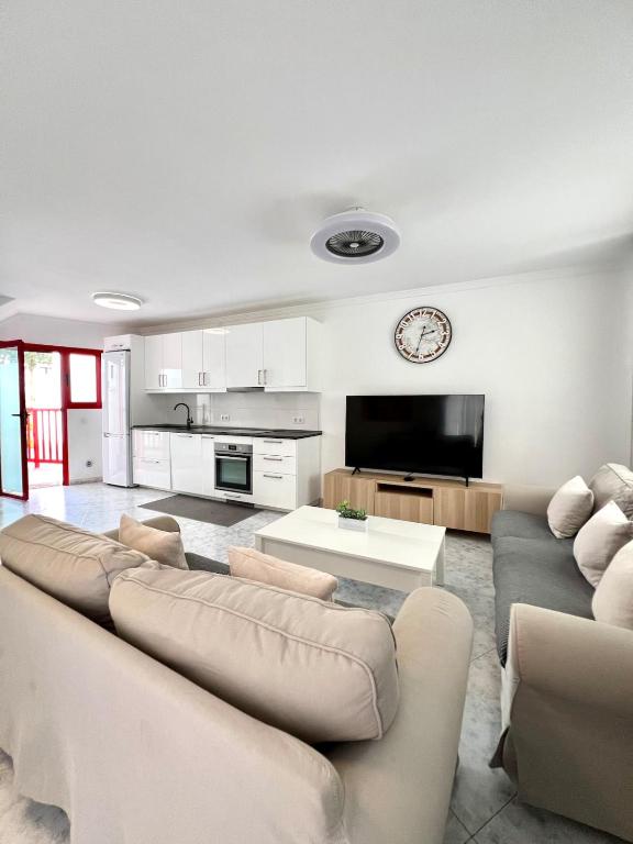 ein Wohnzimmer mit Sofa und Tisch in der Unterkunft Quiet Corner by the Beach in Mogán