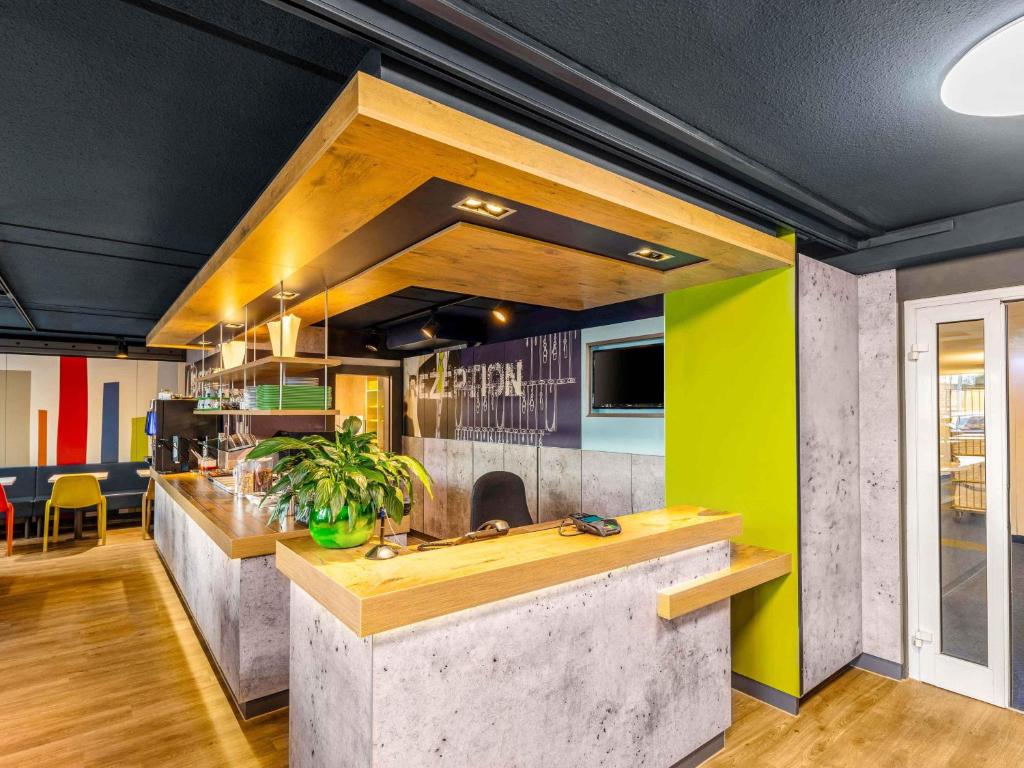 マインツにあるB&B HOTEL Mainz-Südのコンクリートのカウンターと緑の壁のあるキッチン