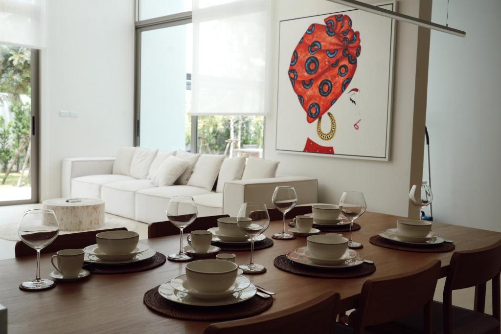 une salle à manger avec une table et des verres à vin dans l'établissement Bangtao Luxury 4 bedroom villa Lux Pride, à Ban Pak Lak
