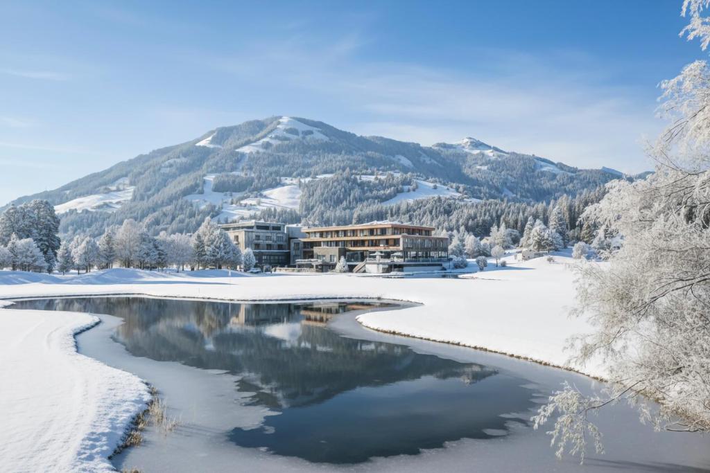 a resort in the snow next to a river at Berg & Golf Apartments Westendorf by ALPS RESORTS in Westendorf