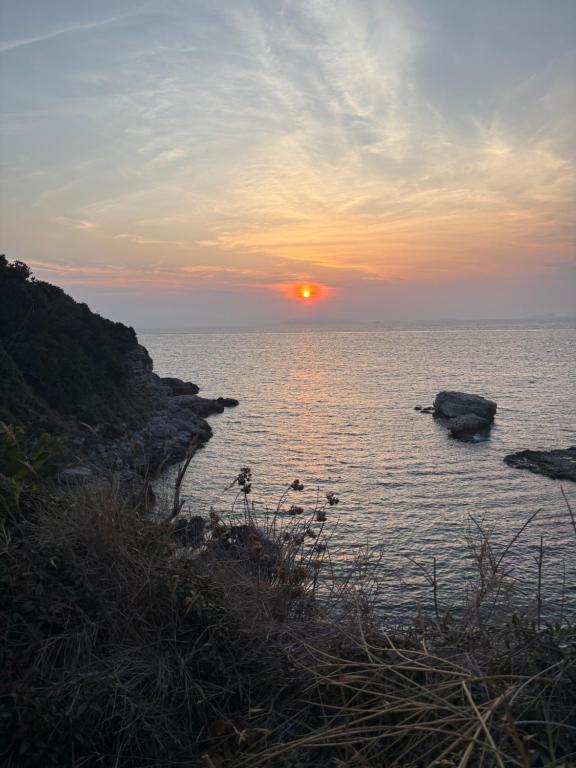 a sunset over a body of water with rocks at Casa Camille in Sorrento in Piano di Sorrento