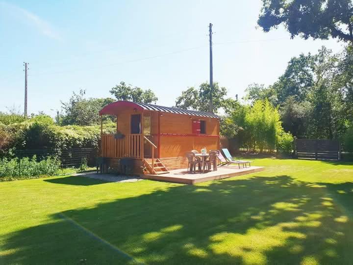a cabin in the middle of a grass field at Roulotte rêve de bohème in Moisson