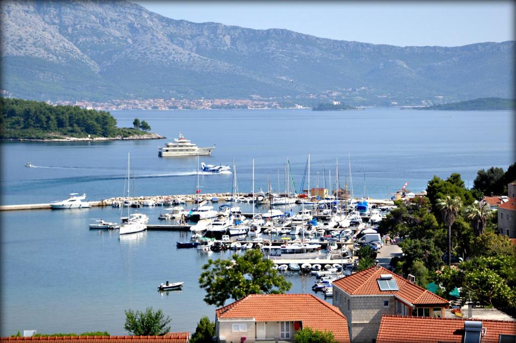 a group of boats docked in a harbor with mountains at Apartments Lumbarda in Lumbarda
