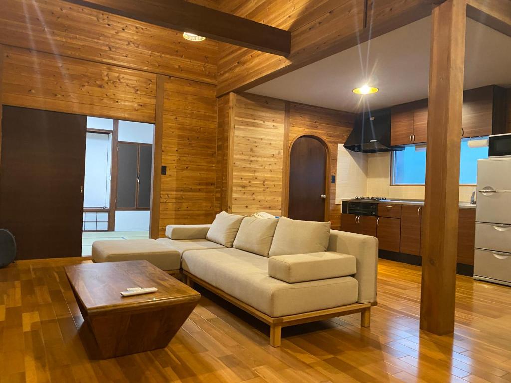 a living room with a couch and a table at Komore Villa Kita-Karuizawa こもれヴィラ北軽井沢 in Tsumagoi