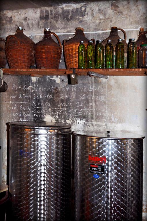 two metal tanks in a kitchen with bottles on a shelf at Apartments Lumbarda in Lumbarda