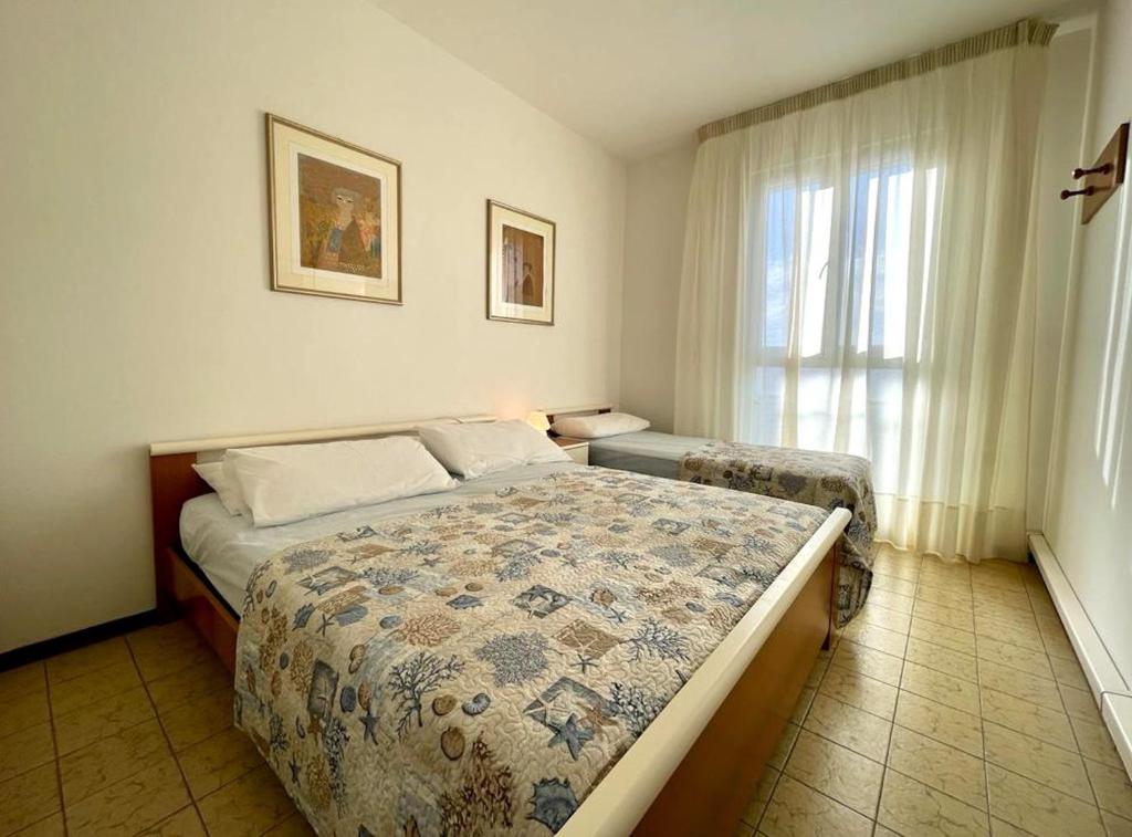 a bedroom with two beds and a window at Apartment for five with balcony in Porto Santa Margherita di Caorle