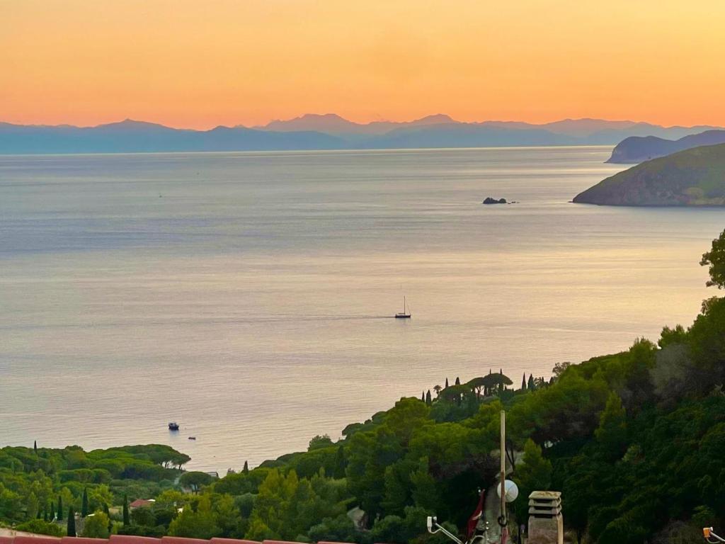 a view of the ocean with a boat in the water at Casina di Nonna Meca by Solturelba in Capoliveri