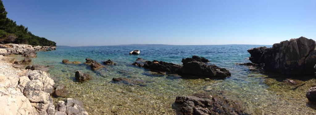 a group of people in the water near some rocks at Apartment Old Town Design in Rab