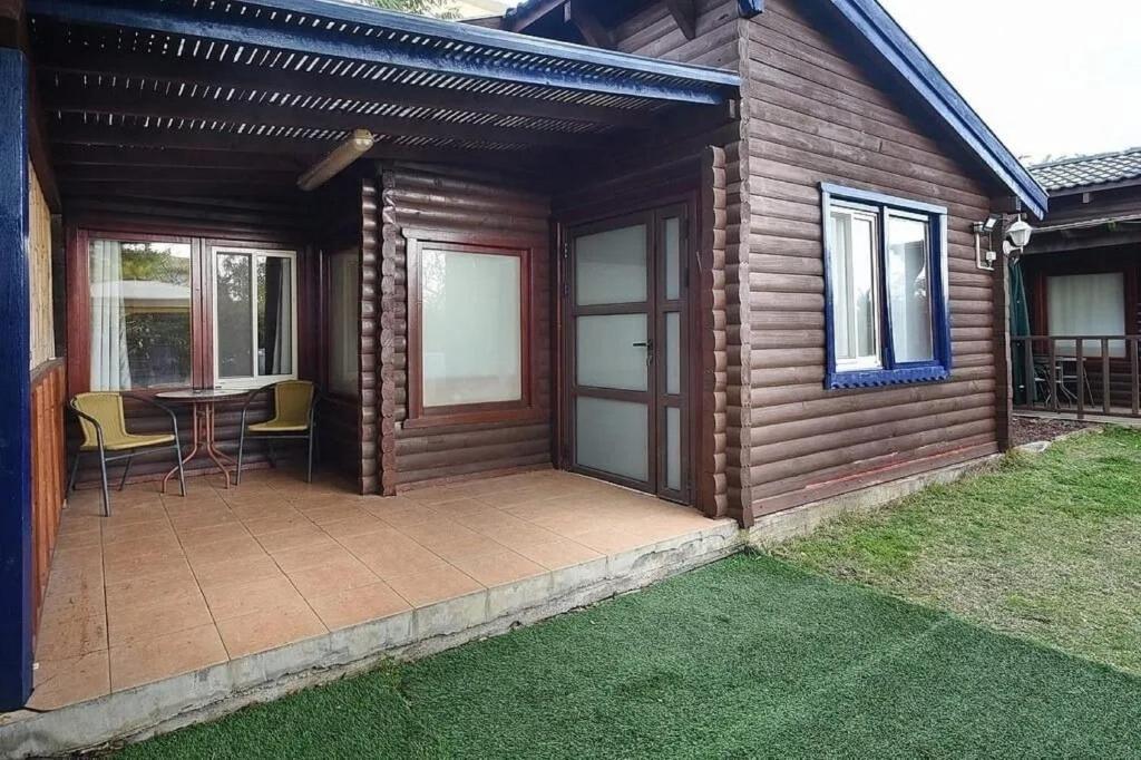a patio of a house with a table and chairs at בקתות לואיז in Had Nes
