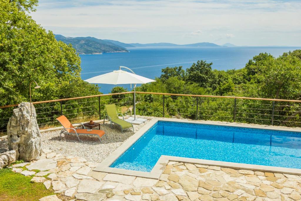 una piscina con vistas al agua en Ivanini secluded stone Villa with a stunning view, en Brseč