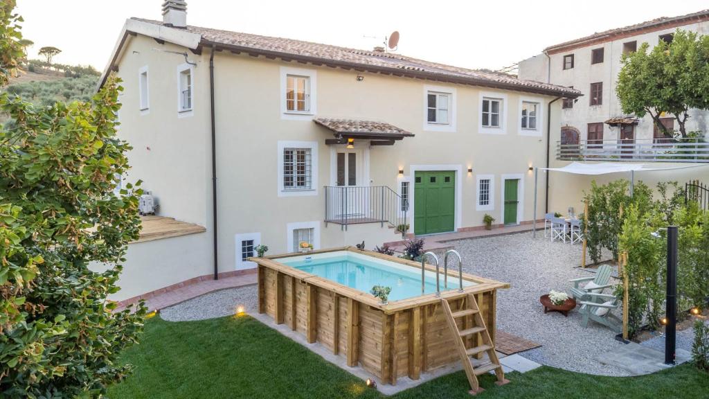 a backyard with a pool and a house at Villa Podere Falcione in San Quirico di Moriano