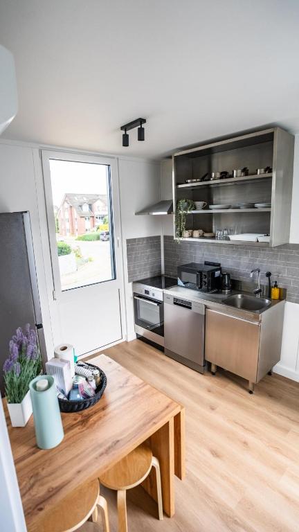 a kitchen with a wooden table and a sink at TheSnoozzze Boardinghouse Winsen - Monteur Apartments in Winsen