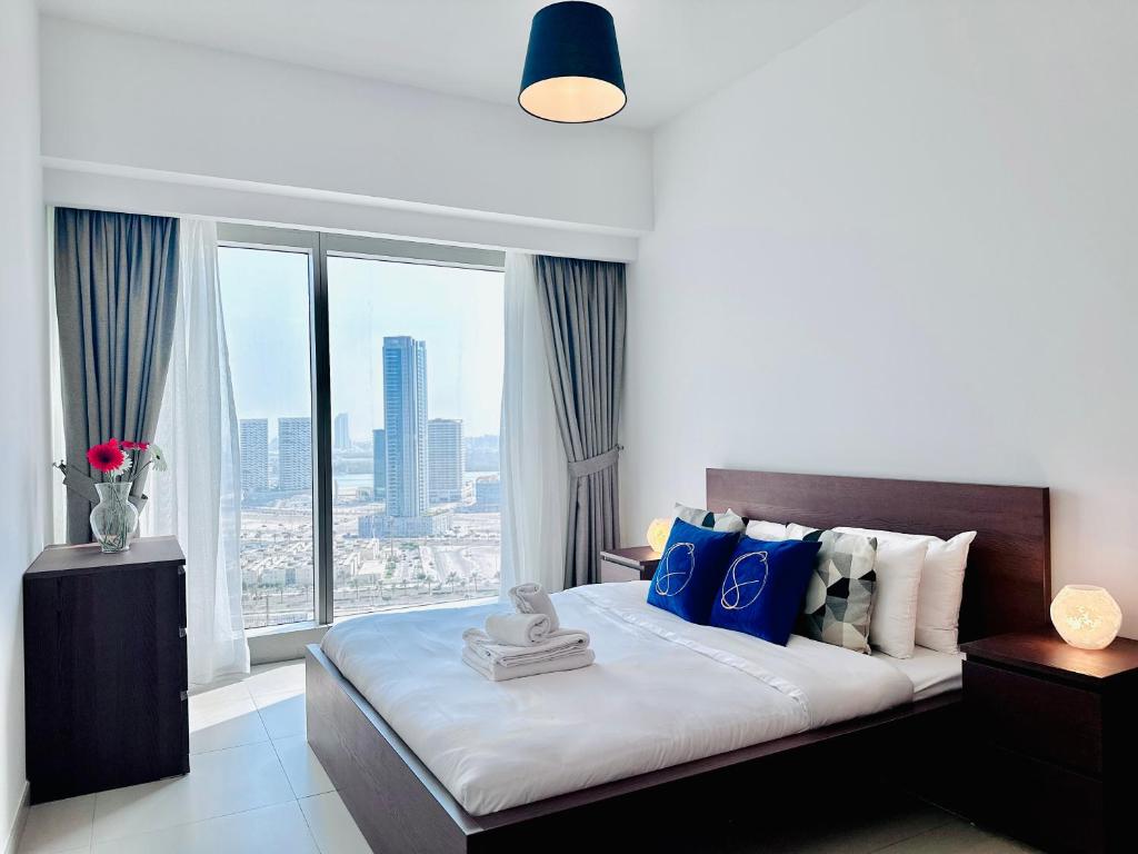 a bedroom with a bed with a large window at Urban Oasis 1BR Apartment in Gate Towers in Abu Dhabi
