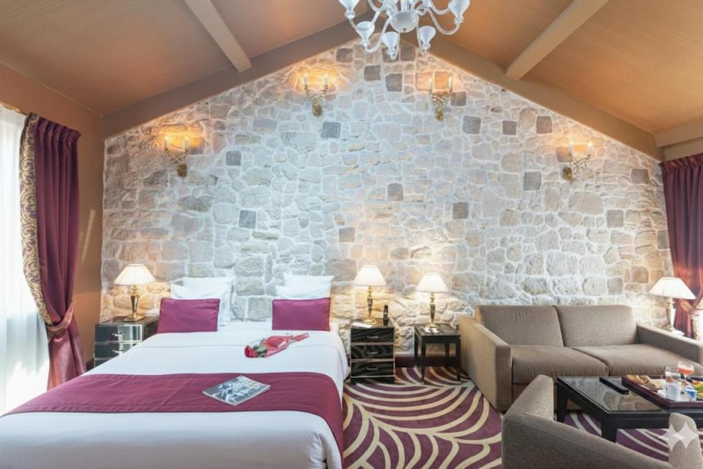 a hotel room with a bed and a stone wall at Hotel Du Beaumont in Paris